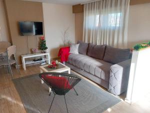 uma sala de estar com um sofá e uma mesa em Apartman Talija em Arandjelovac