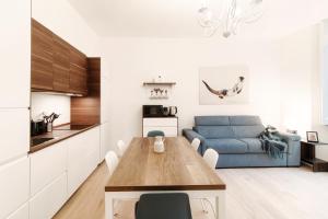 una cucina e un soggiorno con un tavolo e un divano blu di Suite JOIVY BV 66 a Como
