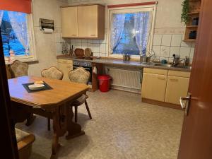 a kitchen with a wooden table and a table and chairs at Monteurzimmer am Holzbach in Maroth