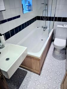 ein Badezimmer mit einer Badewanne, einem WC und einem Waschbecken in der Unterkunft Cosy Cottage in Central Reading Free Parking & Fast Wifi in Reading