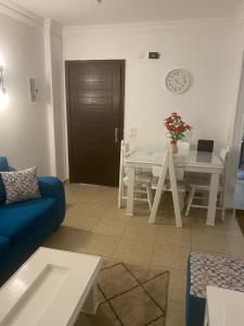 salon z niebieską kanapą i stołem w obiekcie شقة مفروشةومريحةفي مدينتي قريبة من كل الخدمات والحركة w mieście Madinaty