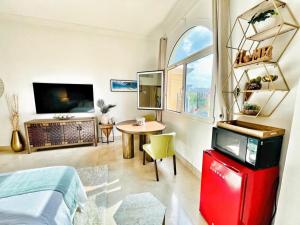 Habitación con cama, mesa y TV. en Peaceful escape near the beach with private garden en Dubái
