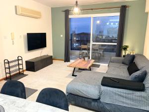 a living room with a couch and a tv at 212 Apartment, A 2-bedroom escape in Paphos