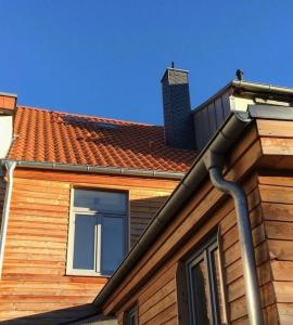 un toit d'une maison avec une cheminée et une fenêtre dans l'établissement Wohlfühlferienhaus - ABC198, à Wismar