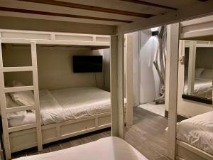 a room with two bunk beds and a television at Boutique Beachfront Hotel on Isla Contadora in Contadora