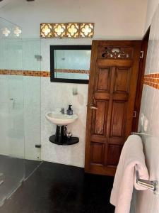 a bathroom with a sink and a wooden door at Finca Sierra Luz in Jericó +44 photos