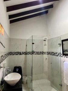 a bathroom with a glass shower and a sink at Finca Sierra Luz in Jericó