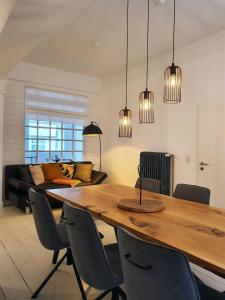 een eetkamer met een houten tafel en stoelen bij Zur Bademutter mit 2 Schlafzimmer - ABC360 in Wismar