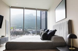 sypialnia z łóżkiem i dużym oknem w obiekcie Lujoso departamento a 5 minutos de San Pedro w mieście Monterrey