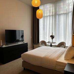 a bedroom with a bed and a flat screen tv at Hotel Grand Canal in Delft
