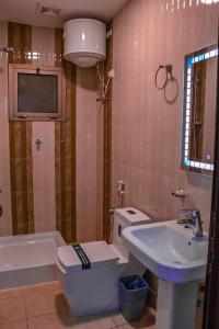 a bathroom with a toilet and a sink and a tv at دانة الشرقية للشقق المخدومة بالدمام Danat Al Sharqiah Serviced Apartments in Dammam