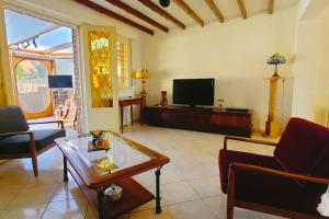 a living room with a couch and a tv at La Cambresienne de Mamie in Cambrai