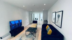 a living room with a couch and a flat screen tv at 2 BED 4 ADULTS IN ROYAL WHARF in London