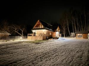 a house on a snowy street at night at GRABNIK55 in Krasnobród
