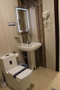 uma casa de banho com um WC e um lavatório em دانة الشرقية للشقق المخدومة بالدمام Danat Al Sharqiah Serviced Apartments em Dammam