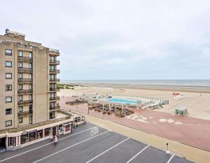 a building next to a beach with a hotel at Modern appartement - Zeezicht - Perfecte ligging in Koksijde