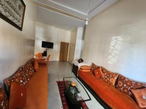 sala de estar con sofá y TV en Targa Flat, en Marrakech