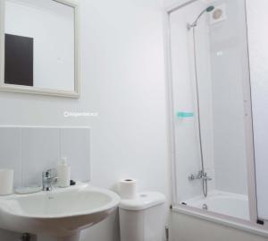 y baño blanco con lavabo y ducha. en Casa completa 3D 2B, amplia comoda y equipada, en Talca