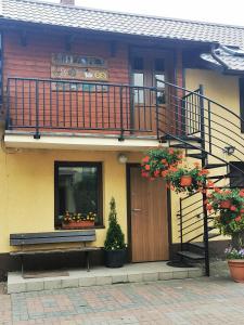 a building with a balcony and a door with flowers at Apartament od Kaszuba in Żuromino