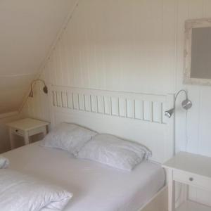 a white bed with two pillows in a bedroom at Utsiktsperle på Reine I Lofoten in Reine
