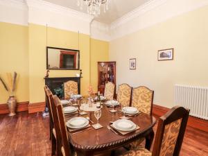 uma sala de jantar com uma mesa de madeira e cadeiras em 23 Chatsworth Square em Carlisle