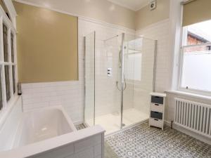 a bathroom with a tub and a shower at 23 Chatsworth Square in Carlisle