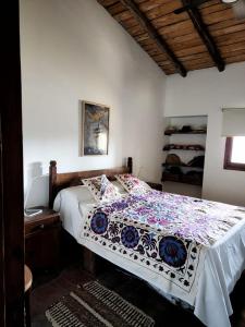 1 dormitorio con 1 cama con edredón de flores en SANTA MARIA REINA en San Rafael