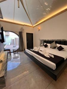 a bedroom with a large bed and a table at The Whispering Palms Resort in Bhopal