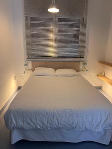 a white bed in a room with a window at Apartamento Waiora in Aguaviva