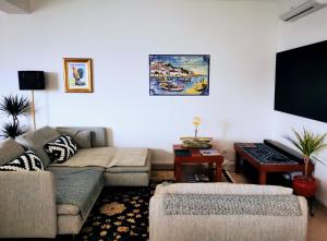 Il comprend un salon doté d'un canapé et d'une télévision à écran plat. dans l'établissement #056 Seaview with Private Park, AC, à Albufeira