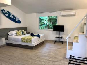 Schlafzimmer mit einem Bett, einem Schreibtisch und einem Fenster in der Unterkunft Casa de las Flores tropical in San Andrés