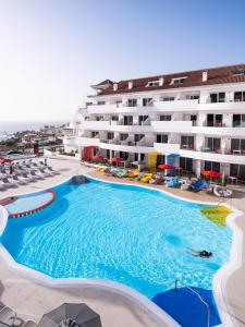 une grande piscine en face d'un hôtel dans l'établissement Sholeo Lodges Los Gigantes, à Puerto de Santiago