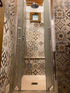 a shower in a room with a tile floor at Agriturismo La Luciana in Castiglione della Pescaia