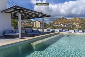 a swimming pool with lounge chairs and a pavilion at Condo near Marina - Downtown - Pool - King in Cabo San Lucas