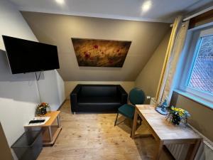 een woonkamer met een bank en een flatscreen-tv bij Lucia's ElbHotelchen in Lauenburg