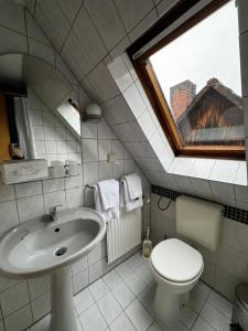 een badkamer met een wastafel, een toilet en een raam bij Lucia's ElbHotelchen in Lauenburg