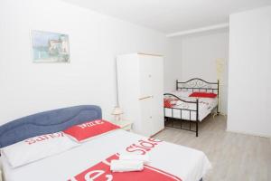 una camera con un letto con una coperta rossa e bianca di Bigger group Apt next to the beach a Jesenice