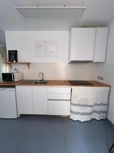 a kitchen with white cabinets and a sink at Apartamento Waiora in Aguaviva