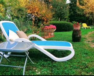 a blue and white chair sitting in the grass at Rez-de-chaussée aménagé in Bergerac