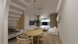 Anemolia Parga Suites في Sarakiniko: غرفة معيشة مع طاولة وكراسي وأريكة