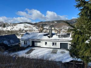 une maison blanche avec de la neige sur le toit dans l'établissement Panoramablick Willingen Schwalefeld, à Willingen