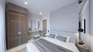 a bedroom with a large white bed and a mirror at Anemolia Parga Suites in Sarakiniko
