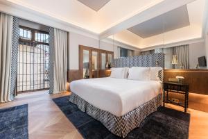 ein Schlafzimmer mit einem Bett und einem großen Fenster in der Unterkunft Palacio Solecio, a Small Luxury Hotel of the World in Málaga + 64 Fotos