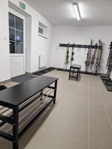 een kamer met ski's tegen een muur met een tafel bij Horský apartmán MIKI in Filipovice