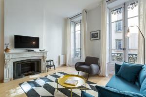 a living room with a blue couch and a fireplace at Hallmark - Location T2 - Lyon 2 in Lyon