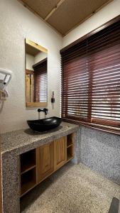 a bathroom with a black sink and a mirror at MăngDiang Boutique Hotel in Kon Von Kla