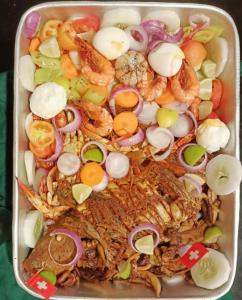 a tray of food with seafood and vegetables at Palm Beach Resort Ceylon in Jaffna