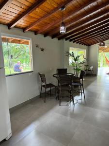 jadalnia ze stołem i krzesłami oraz oknem w obiekcie Casa de campo Itirapina/SP w mieście Itirapina