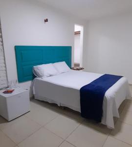une chambre avec un grand lit et une tête de lit bleue dans l'établissement Trilha dos Ventos Cumbuco, à Cumbuco