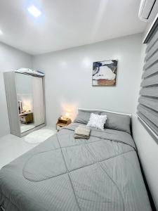 - une chambre avec un grand lit et un miroir dans l'établissement Modern Cozy Apartment 2 - Netflix & Free Parking, à Ángeles